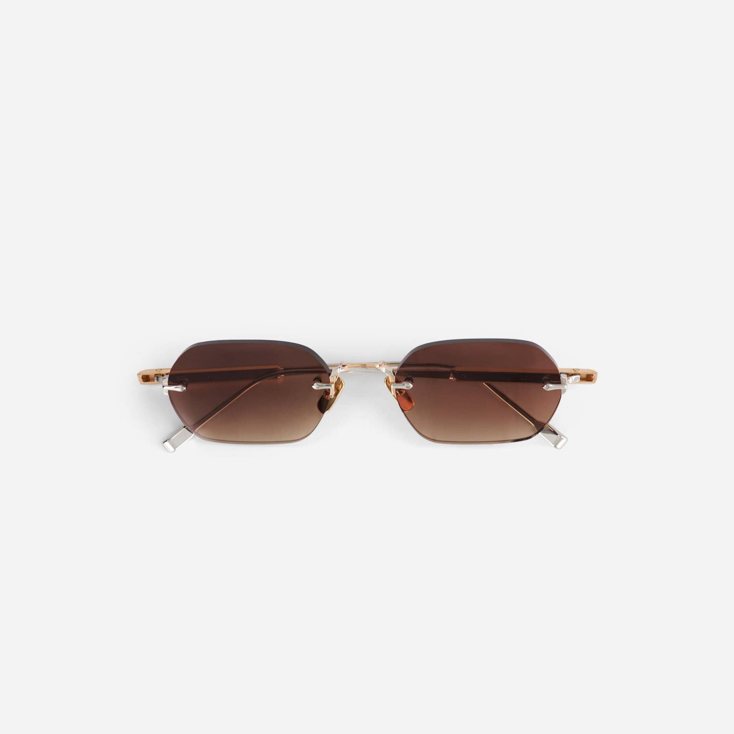 Terebellum IV S1004 sunglasses feature a sleek rimless design with rose gold and platinum accents, paired with elegant brown gradient lenses.