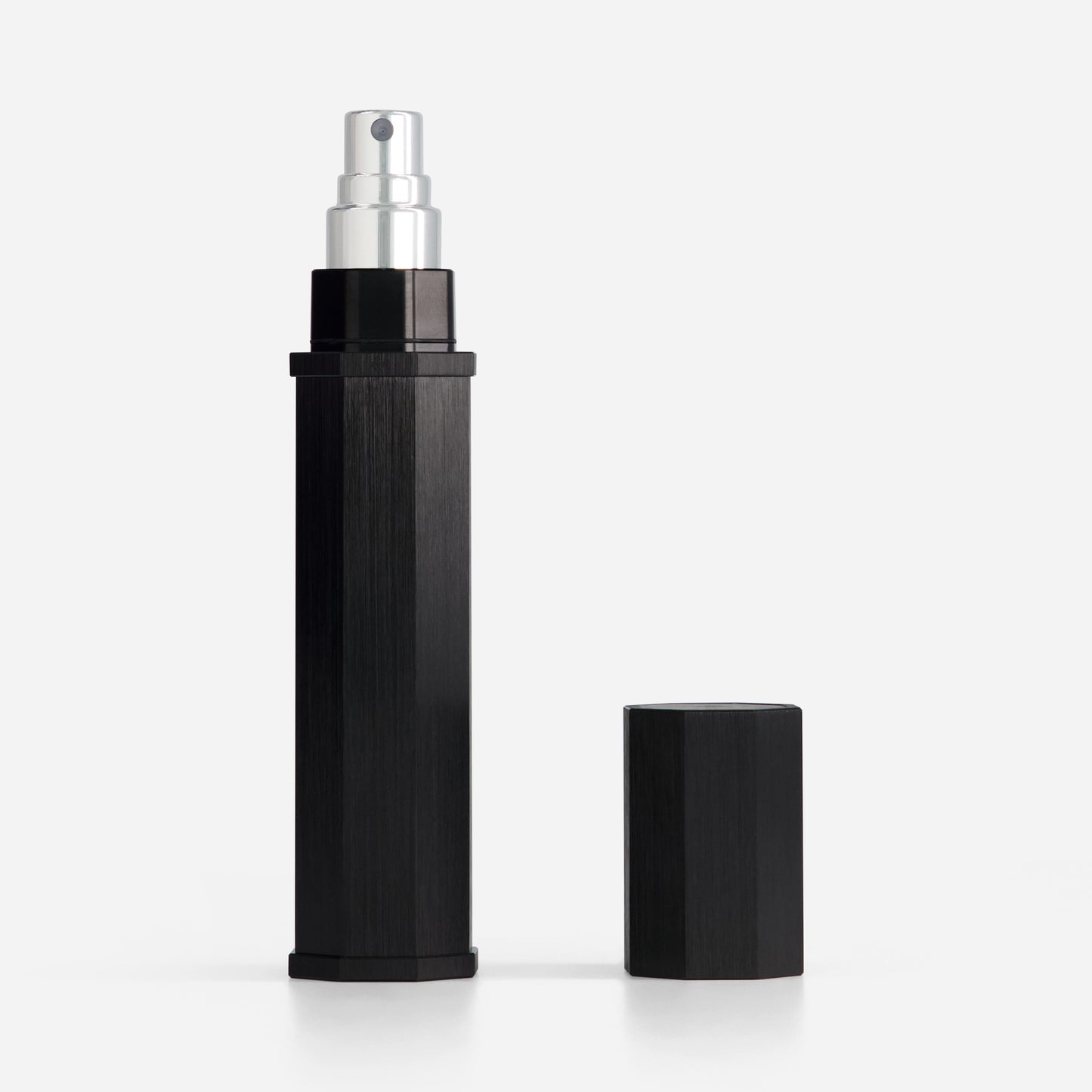 Black spray bottle with silver nozzle on a white background